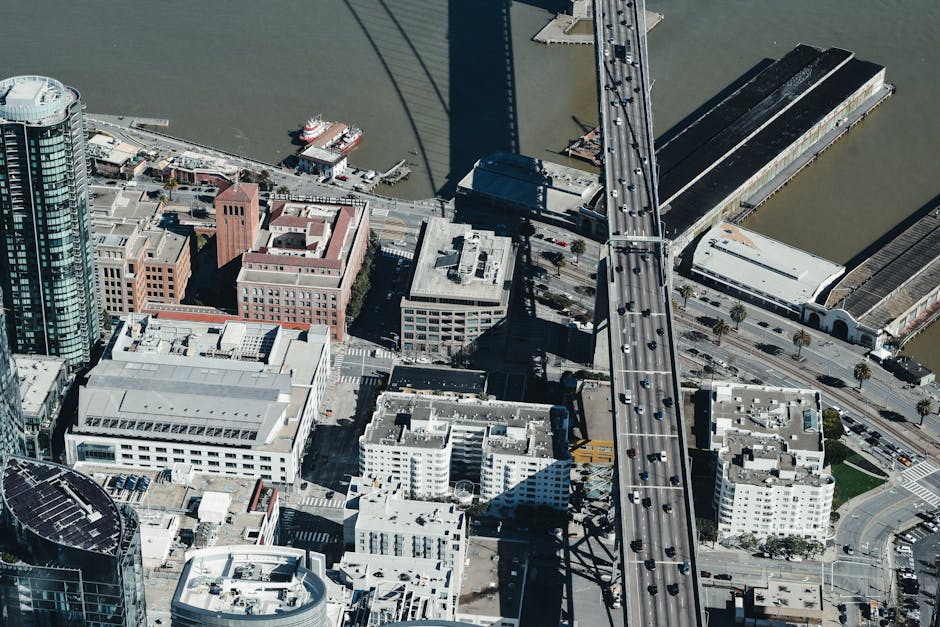 High-angle aerial view of a cityscape featuring buildings, roads, and a prominent bridge.